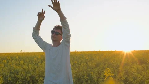 Happy young man having fun and dancing in yellow field during sunset Stock Footage 89449435