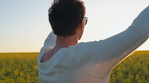 Happy young man having fun and dancing in yellow field during sunset Stock Footage 89457309