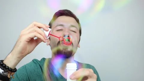 Happy young man having fun blowing soap bubbles Stock Footage 163093055