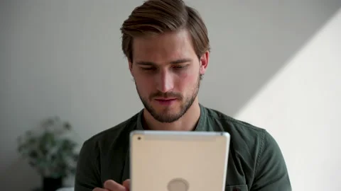 Happy young man at home using tablet surfing web, shopping use social media Stock Footage 220866340
