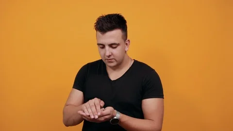 Happy young man keeping tiny present box on palm, pointing finger on it. Stock Footage 122687852