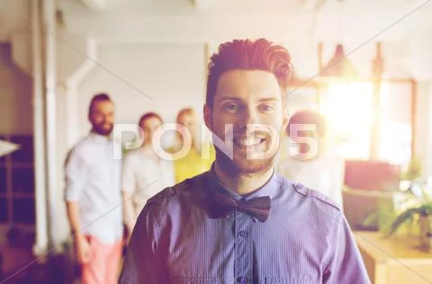 Happy young man over creative team in office Stock Photos