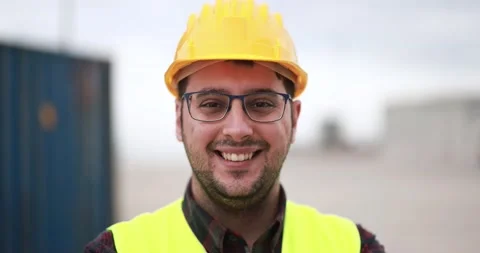 Happy young man smiling on camera working at freight terminal port on background Stock Footage 179974110