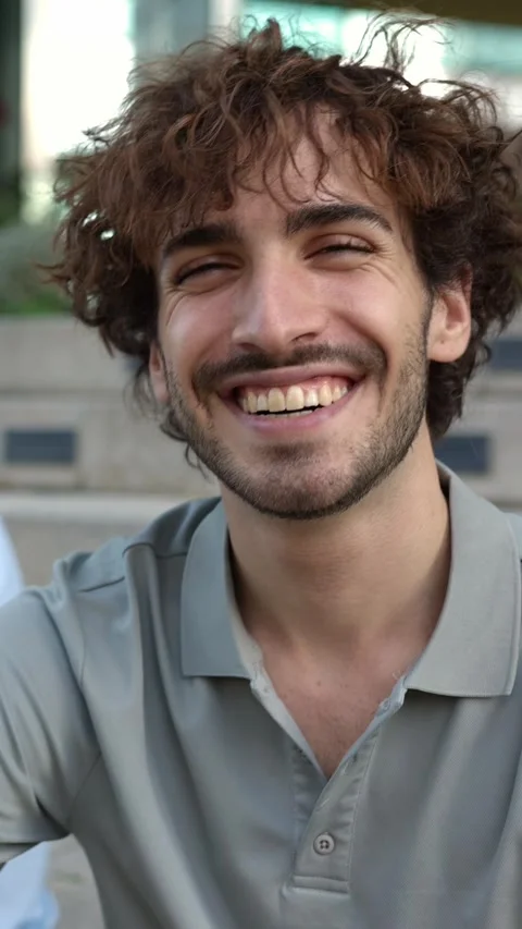 Happy young man smiling at camera with multiracial female friends on background Stock Footage 310779034