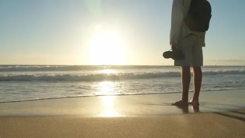 Happy young man standing on a sandy ocean beach at a beautiful summer sunse.. Stock Footage 253272991