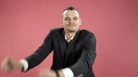 Happy young man in a suit dancing against pink background. Stock Footage 119647015