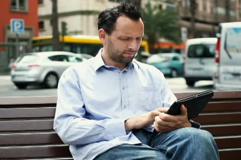Happy young man with tablet computer in the city NTSC Stock Footage 10860154
