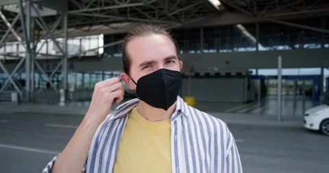 Happy young man takes off protective face mask outdoors. Stock Footage 154000258