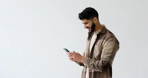 Happy young man text messaging on mobile phone Stock Footage 196077035
