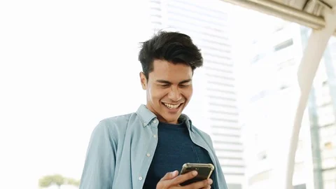 A Happy Young Man Using Mobile Phone in Urban City. Dolly Zoom In. Slow Motio Stock Footage 123148851