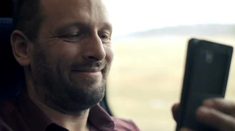 Happy, young man using smartphone during train ride  Stock Footage 62707581