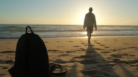 Happy young man walking into a sandy ocean beach on a sunny summer day, wit.. Stock Footage 253271749