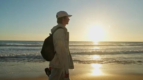 Happy young man walking on a sandy ocean beach on a sunny summer day. Stock Footage 305828872