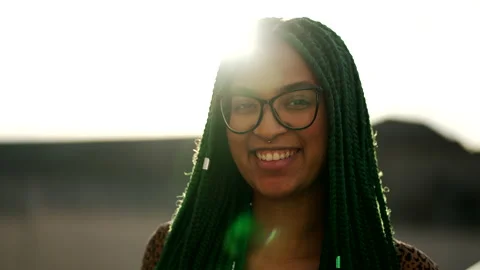 A happy black latin girl with green Box Braids hairstyle smiling