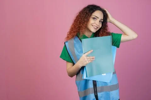 Happy, young model posing indoors, raising hand, looking at camera, holding Stock Photos