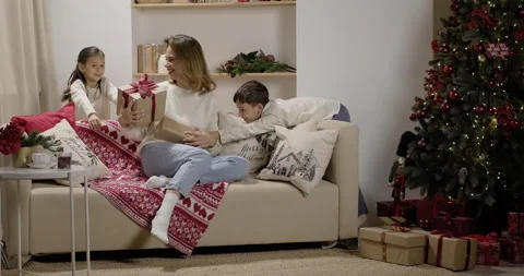 Happy young mom receiving gift boxes from little loving children Stock Footage 222811009