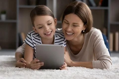 Happy young mother and small daughter using digital tablet. Stock Photos