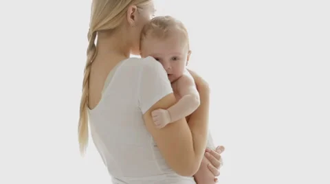 Happy young mother with her baby boy standing in front of big window. People Stock Footage