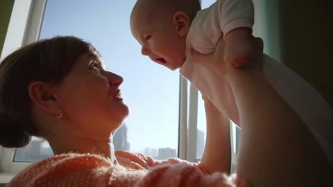 Happy young mother throws her baby up and kisses. Vídeo Stock 192320482