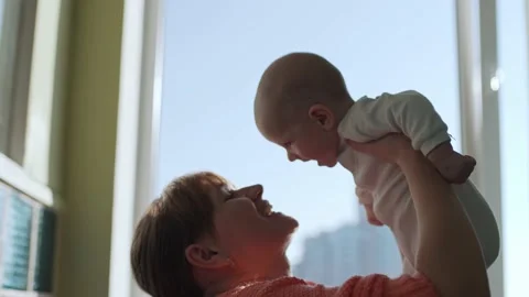 Happy young mother throws her baby up and kisses. Stock Footage 192947748