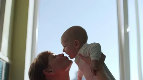 Happy young mother throws her baby up and kisses. Stock Footage 192948056