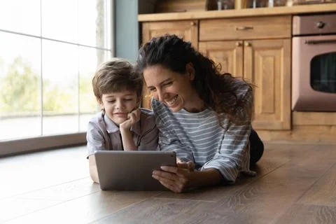 Happy young mother using tablet with little kid. Stock Photos