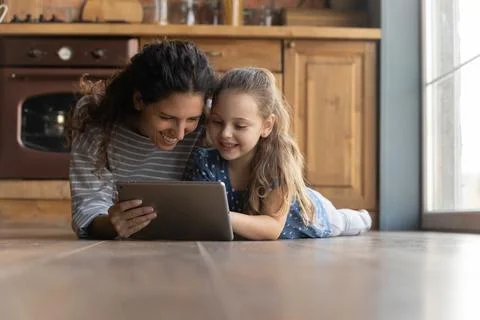 Happy young mother using tablet with little kid daughter. Stock Photos