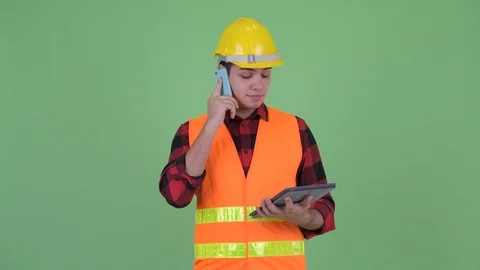Happy young multi ethnic man construction worker talking on the phone while Stock Footage 111242774