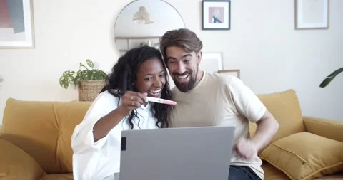 Happy young multiethnic couple making a video call showing a pregnancy test. Stock Footage 169857606