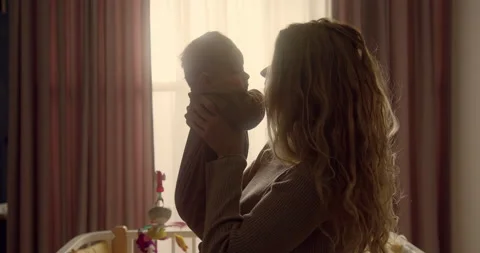 Happy young mum taking in hands newborn baby boy showing love and tenderness Video stock 147941378