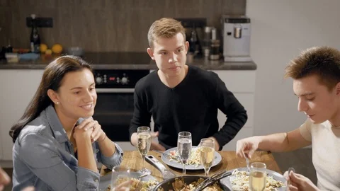 Happy young people at table in kitchen Stock Footage 99095854