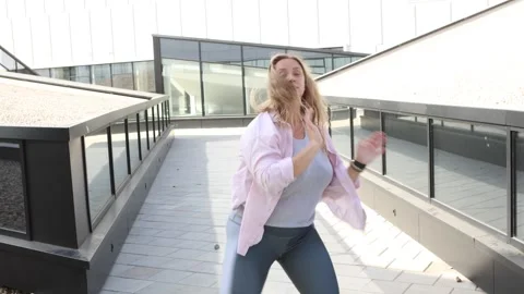 Happy Young plus size blonde woman dancing outside on summer day, feeling Stock Footage 301083383