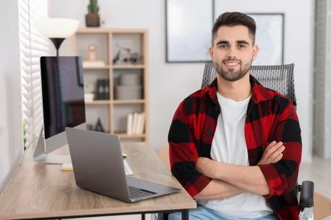 Happy young programmer working at desk in office Stock Photos
