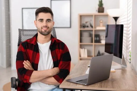 Happy young programmer working at desk in office 写真素材