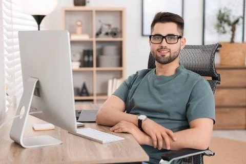 Happy young programmer working with at desk in office Stock Photos