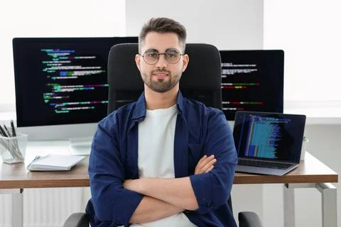 Happy young programmer working at desk in office 스톡 사진