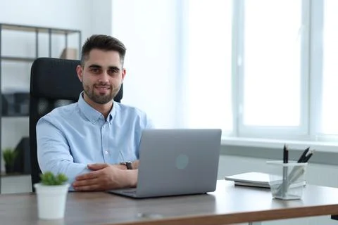 Happy young programmer working with laptop in office 写真素材