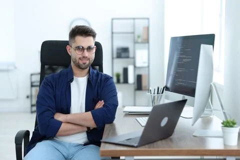Happy young programmer working with laptop in office Stock Photos