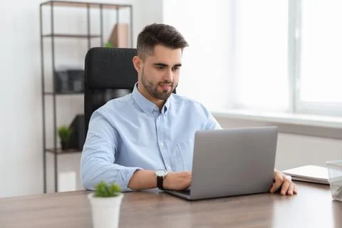 Happy young programmer working with laptop in office Foto stock