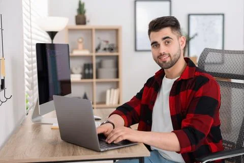 Happy young programmer working with laptop in office 写真素材