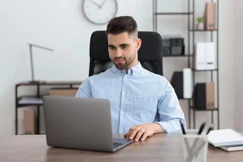 Happy young programmer working with laptop in office 写真素材
