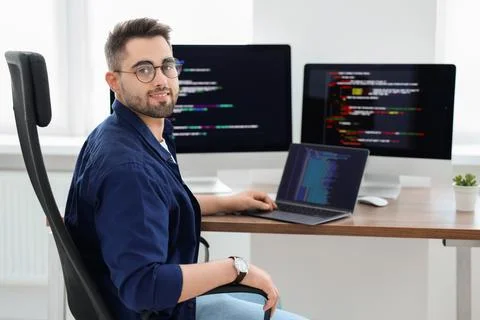 Happy young programmer working with laptop in office 写真素材