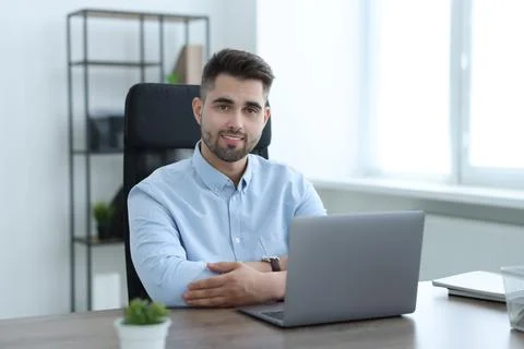 Happy young programmer working with laptop in office 写真素材