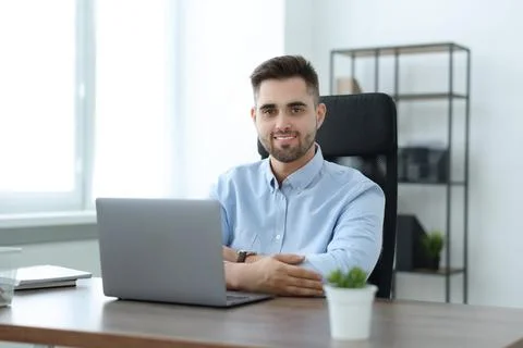 Happy young programmer working with laptop in office 写真素材