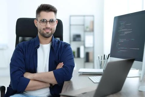 Happy young programmer working with laptop in office 写真素材