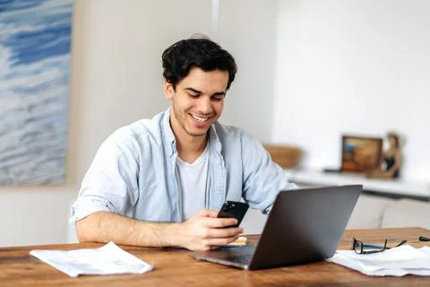 Happy young smart hispanic guy, freelancer, manager or student, working or Stock Photos