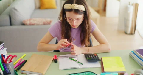 Happy Young Smart Student Doing Math Homework and Writing in a Notebook Stock Footage 277148303