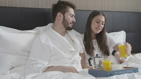 Happy young smiling couple having romantic breakfast in bed Stock Footage 73349190