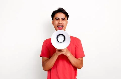 Happy young southeast asian man shouting through megaphone for big announce.. Stock Photos