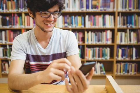 Happy young student using mobile phone 스톡 사진